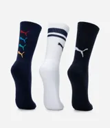 Kit de tres pares de medias deportivas Puma de caña larga, confeccionadas en algodón. Incluye un par blanco con rayas y logo azules, un par negro con rayas y logo blancos, y un par liso de color azul.