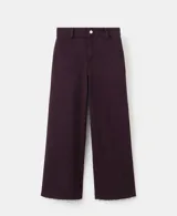 Jeans color bordó, de corte wide leg y tiro medio, con bolsillos laterales y traseros, y terminación sin dobladillo en los tobillos.