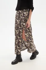 Falda larga de corte recto con abertura lateral pronunciada, confeccionada en tejido fluido con estampado abstracto en tonos tierra y crema.