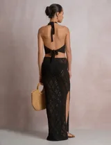 Top crop de tejido calado beige, con escote halter y patrón geométrico de rombos.