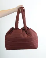 Bolso tipo tote bag acolchado color bordó, con asas de hombro tubulares y logo estampado en el frente.