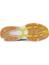 Championes deportivos UA Sola con diseño retro-futurista. Presentan una combinación de malla técnica y superposiciones sintéticas en tonos crema, con detalles en plateado metalizado, amarillo vibrante y azul claro. Incluyen entresuela de EVA acolchada y suela de goma color caramelo.