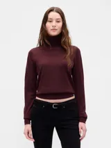 Buzo de punto con cuello alto tipo polera, de corte ajustado y manga larga.