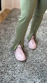 Calza verde oliva de morley, corte ajustado, con cierres de 15 cm en los tobillos.