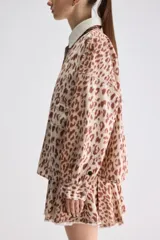 Sobrecamisa de calce relajado y estampado animal print con diseño de leopardo. Cuenta con cuello camisero en color blanco de textura acanalada, cierre frontal de botones a presión, mangas largas y bolsillos frontales aplicados.