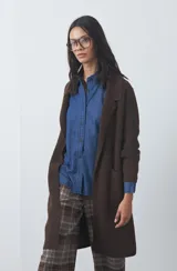 Cardigan de tejido de punto gris, con silueta larga, frente abierto, solapas clásicas y bolsillos aplicados en los laterales.