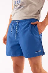 Short de baño azul con cintura elástica y cordón ajustable. Tiene dos bolsillos laterales y un bolsillo trasero.