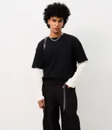 Pantalón masculino de sarga de algodón en color negro, con corte baggy balloon de piernas amplias y leve ajuste en los puños. Diseño de acabado liso, con amplios bolsillos delanteros y llavero removible en la cintura.