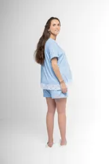 Pijama maternal de algodón gris con textura acanalada, compuesto por una remera de manga corta con broches laterales para facilitar la lactancia y detalle de puntilla blanca en el ruedo, y un short a juego con cintura ajustable.