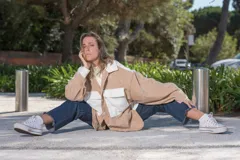 Camisa de pana color beige con detalles en blanco, de corte oversize, con cuello clásico, cierre frontal con botones y bolsillos de parche en el pecho.