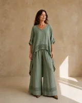 Pantalón verde de lino con diseño holgado de pierna ancha y detalle de tejidoado perforado en el bajo.