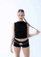 Top sin mangas de tul negro, con diseño reversible que permite variar la transparencia entre el frente y la espalda. Presenta un corte ajustado al cuerpo y cuello redondo.