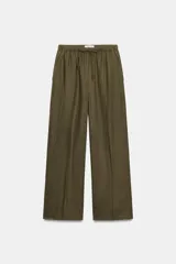 Pantalón recto de lino color verde militar, de tiro medio con cintura elástica ajustable mediante cordón y bolsillos delanteros.