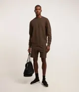 Buzo deportivo color verde claro, de manga larga y cuello redondo. Confeccionado en tejido de poliéster, viscosa y elastano.