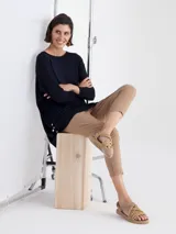 Pantalón capri color beige con detalle de tres botones en el ruedo.