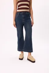 Pantalón de jean azul oscuro, de tiro medio y corte acampanado.