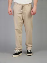 Pantalón de lino color beige, con corte recto y cintura con cordón ajustable.