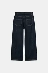 Jeans de tiro alto con diseño de pierna ancha y cinco bolsillos. Presenta cierre frontal con cremallera y botón metálico.