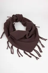 Bufanda triangular tejida en punto, color marrón oscuro, con detalle de flecos en los bordes. Diseño versátil que puede utilizarse como bufanda o poncho.