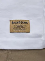 Remera blanca de algodón con cuello redondo y manga corta. Presenta un estampado central con un diseño abstracto y texto en japonés.