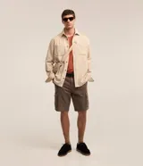 Bermuda cargo para hombre en sarga gris oscuro, con bolsillos laterales con solapa y cierre de botón y cremallera.
