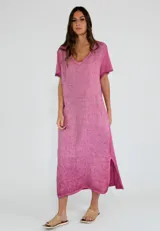 Vestido largo de lino y algodón, color fucsia, con cuello en V, mangas cortas con bordes desflecados y tajos laterales en el ruedo.
