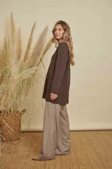 Buzo de punto color marrón, de corte holgado y largo, con cuello redondo, mangas largas y dos bolsillos frontales con detalle de desflecado en el borde superior.