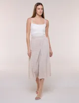 Falda midi evasé de color beige con diseño a rayas horizontales y verticales blancas, cintura alta elastizada y caída fluida.