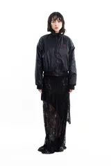 Campera bomber negra de tela satinada con bordado rojo en el pecho. Es reversible.