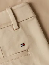 Pantalón de vestir color beige, de corte slim, con bolsillos laterales y traseros. Incluye cinturón de tela con hebilla metálica y rayas horizontales en rojo, blanco y azul.