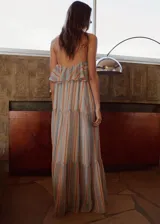 Vestido largo con diseño halter, estampado de rayas verticales en tonos celestes, naranjas y blancos, con detalle de volantes en el escote y abalorios en el cuello.
