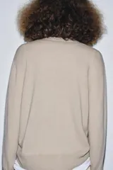 Jersey de punto liso color verde, con cuello redondo y manga larga. Confeccionado en hilatura de lana 100% con tacto suave.