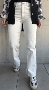 Pantalón de jean color natural, de corte recto con tajos en el lado interno de la pierna y costuras color oro.