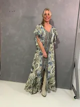 Vestido largo de seda con estampado paisley en tonos azules, celestes y crudo, escote en V con cordón y borlas, y mangas cortas fluidas con volados.