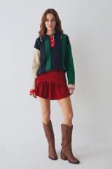 Buzo estilo polo de lambswool con diseño color block a rayas verticales en tonos beige, marrón y rojo. Presenta cuello camisero, cartera frontal con botones, mangas largas con coderas y tajos laterales en el ruedo.