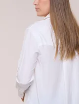 Camisa de calce relajado color celeste, confeccionada en tejido de textura suave y fluida. Presenta cuello camisero y abotonadura frontal, mangas largas con puño ancho y ruedo curvo.