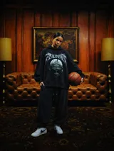 Hoodie negro de corte amplio con estampa frontal de Dennis Rodman y tipografía estilo metal en la parte superior. Cuenta con capucha con cordones ajustables y bolsillo tipo canguro.