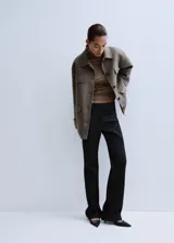 Chaqueta estilo overshirt de paño color gris, con cuello solapa, cierre frontal de botones oscuros, bolsillos con solapa en el pecho y bolsillos aplicados en la parte inferior.