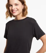 Blusa básica de cuello redondo y manga corta con detalle de dobladillo, confeccionada en tejido de viscosa con elastano.