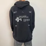 Canguro oversize de color negro con capucha y bolsillo frontal. Presenta un estampado gráfico en la espalda que incluye un esqueleto de pez y texto descriptivo en color blanco.