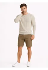 Sweater de punto color beige, de cuello redondo y manga larga, con diseño texturizado de rayas verticales sutiles.