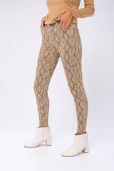 Pantalón de jean ajustado con estampado de piel de serpiente en tonos marrones.