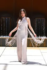 Mono largo azul con escote halter cruzado y detalle de flecos en los laterales.