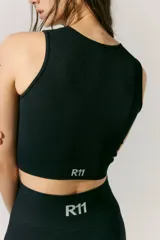 Top deportivo negro sin mangas, tejido en morley sin costuras. Presenta escote redondo alto y logo tejido a contratono en la espalda.