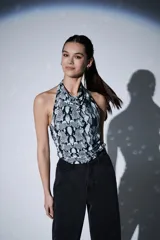Top sin mangas con cuello halter y diseño ajustado al cuerpo, con estampado de piel de serpiente en tonos grises y negros.