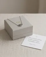 Collar de acero con cadena fina y dije compuesto por dos corazones entrelazados.