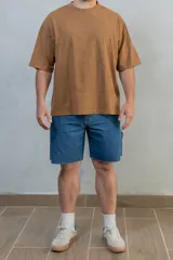 Bermuda de jean azul con bolsillos laterales y traseros, y bolsillo adicional en la pierna derecha.