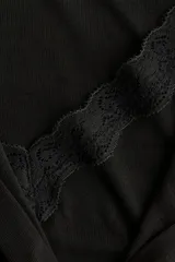 Saco entallado de punto suave, color negro, con cuello redondo y cierre frontal de botones. Incorpora un panel interior cosido con efecto de top lencero y escote en V con ribete de encaje.