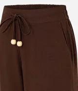 Pantalón de corte recto confeccionado en mezcla de viscosa y lino. Presenta cintura elástica con cordón ajustable y bolsillos laterales.