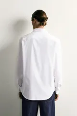 Camisa de corte slim fit confeccionada en tejido de fácil planchado, con cuello italiano, manga larga con puños abotonados y cierre frontal de botones.